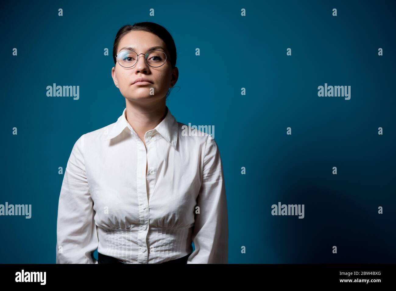 une fille avec des lunettes et une chemise blanche ne s'exprime pas toutes les émotions Banque D'Images