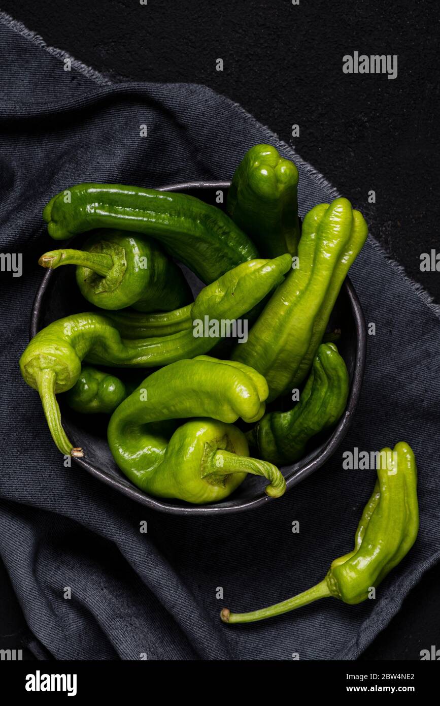 Vue du dessus. Dans le bol en métal, poivrons verts et bonbons italiens en forme de cône irrégulier. Encore la vie Banque D'Images