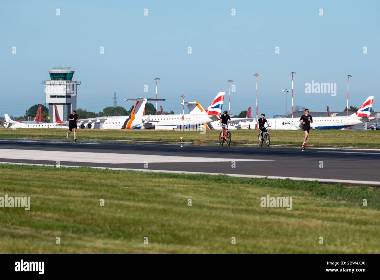 Aéroport de Londres Southend, Essex, Royaume-Uni. 29 mai 2020. Un cycle de course de charité a lieu sur la piste de l'aéroport de Southend pour recueillir des fonds pour le NHS. Normalement, l'aéroport serait trop occupé par les vols, mais la pandémie du coronavirus a interrompu les déplacements. EasyJet et Ryanair voteraient leurs horaires occupés à cette période de l'année, mais les avions de ligne sont garés. 40 membres de l'équipe de l'aéroport se sont portés volontaires pour courir ou parcourir la longueur de la piste par étapes, afin d'atteindre un total de 290 km - la distance jusqu'à l'une des destinations les plus populaires de l'aéroport - Amsterdam Banque D'Images