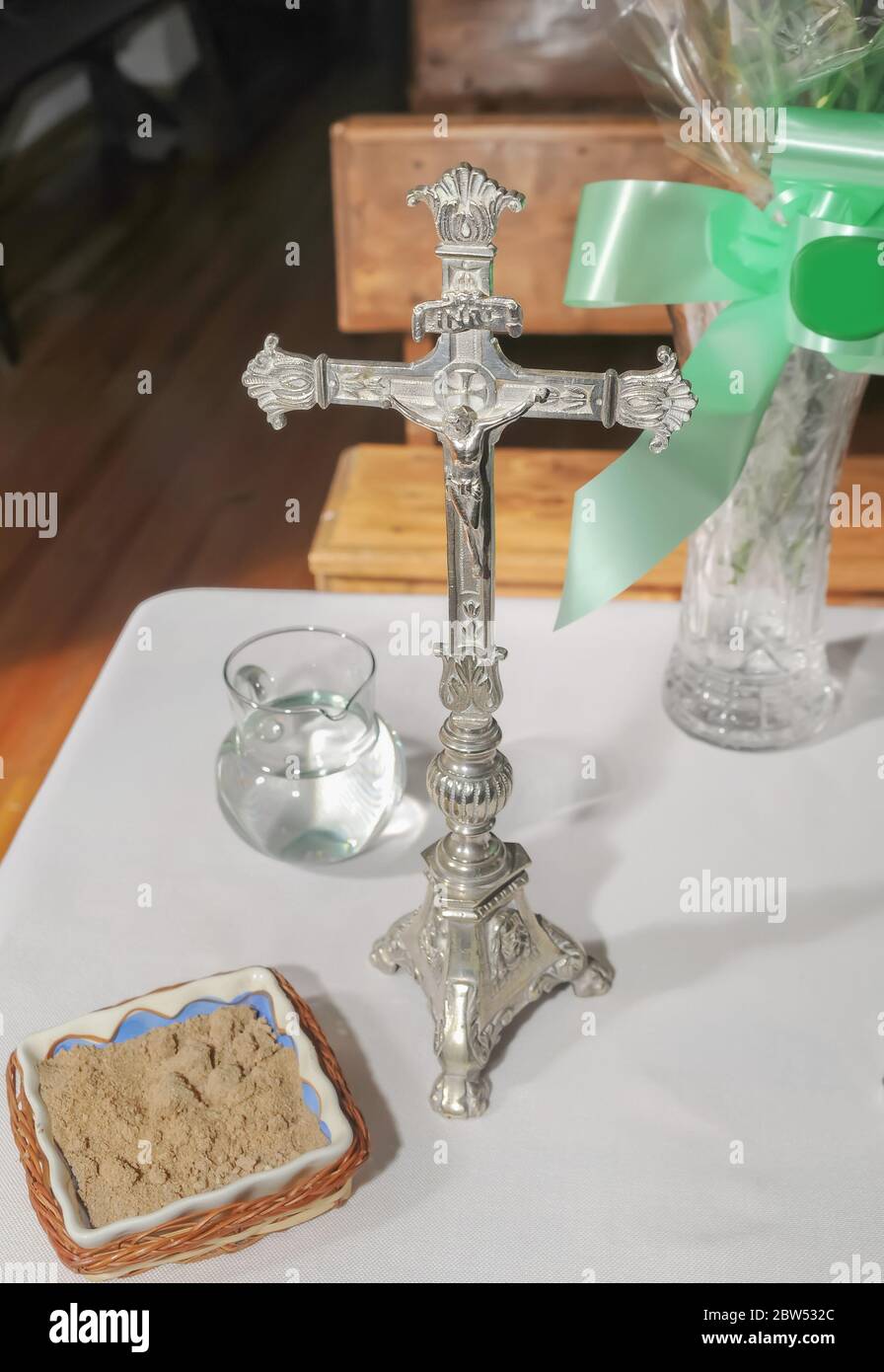 Christ crucifié dans le vieux crucifix d'argent à côté d'autres accessoires pour l'Eucharistie sur une table. Banque D'Images
