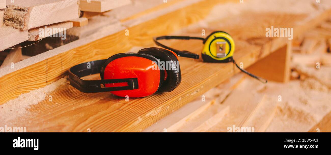 Bannière d'équipement de protection auditive et oculaire pour les fabricants d'armoires et les travailleurs de la production de bois. Poste de travail Carpenter avec casque de protection, verre Banque D'Images