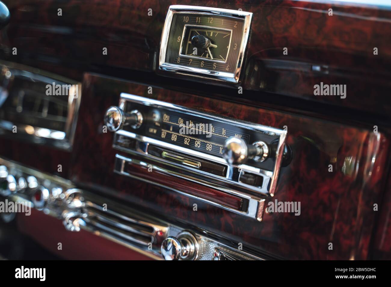 Intérieur luxueux d'une vieille voiture américaine classique. Tableau de bord en bois avec radio et horloges. Banque D'Images