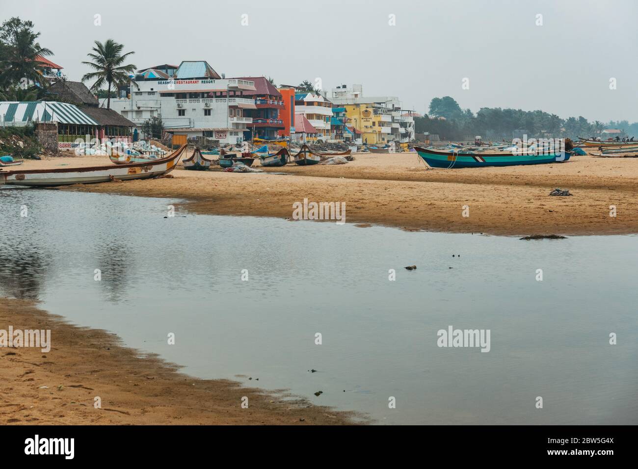 Des bateaux de pêche sillonneurs la plage de Mahabalipuram, en Inde, par une journée nuageux Banque D'Images