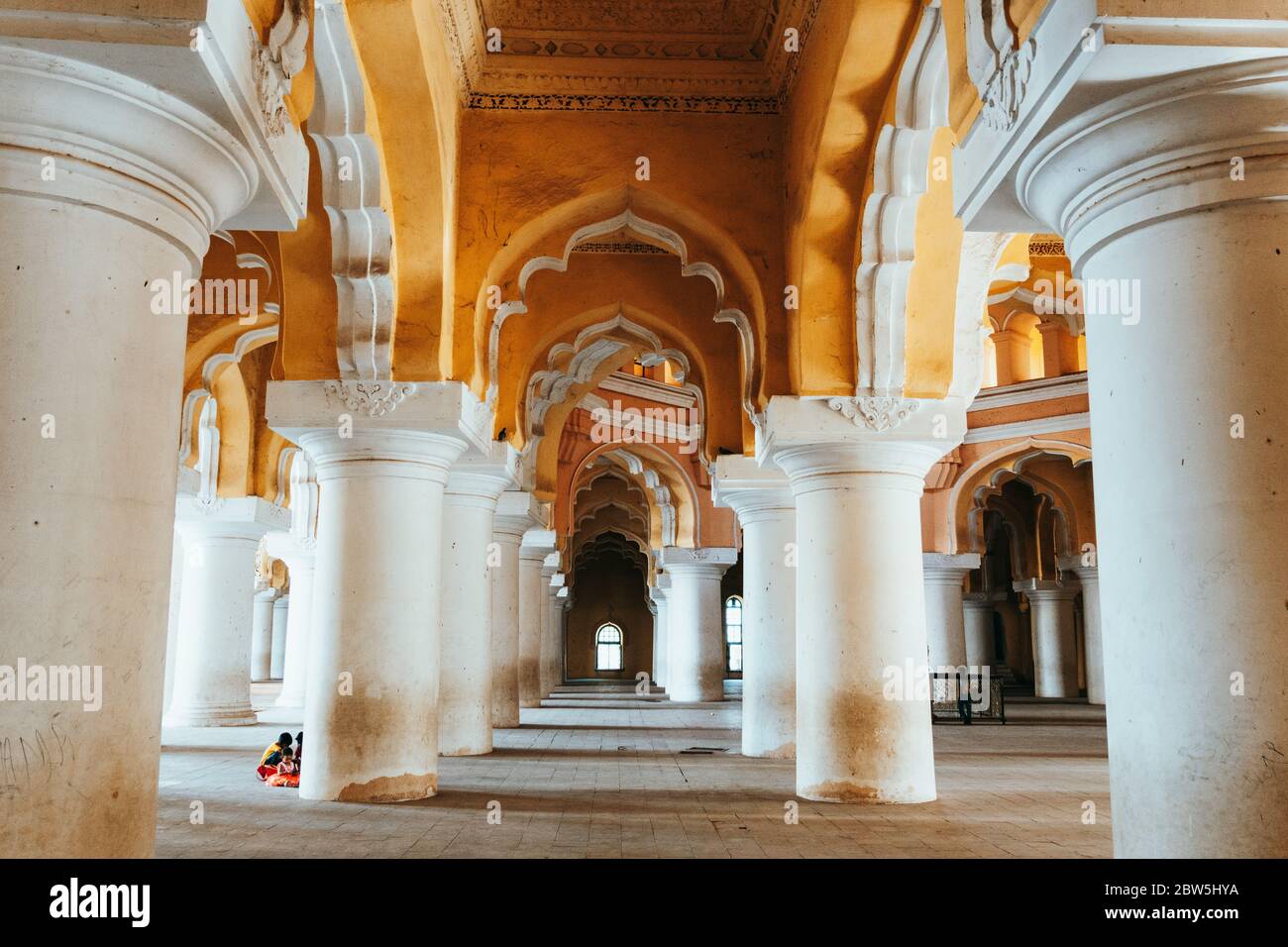 Vue à travers les arcades jaune et blanche du Palais Thirumalai Nayakkar, Madurai, Inde Banque D'Images