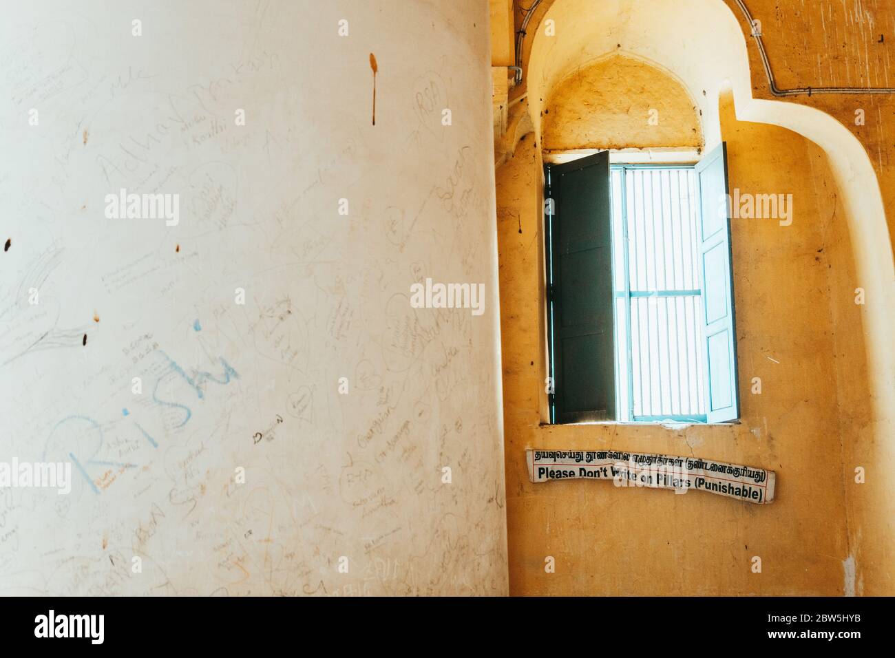 Un panneau indique "s'il vous plaît n'écrivez pas sur les piliers (punissable)" à côté d'un pilier couvert d'écriture au Palais Thirumalai Nayakkar, Madurai, Inde Banque D'Images