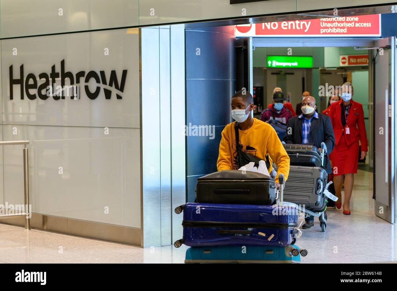 Un Britannique qui pousse ses bagages arrive au terminal 2 de Heathrow depuis Lagos, au Nigeria. Banque D'Images