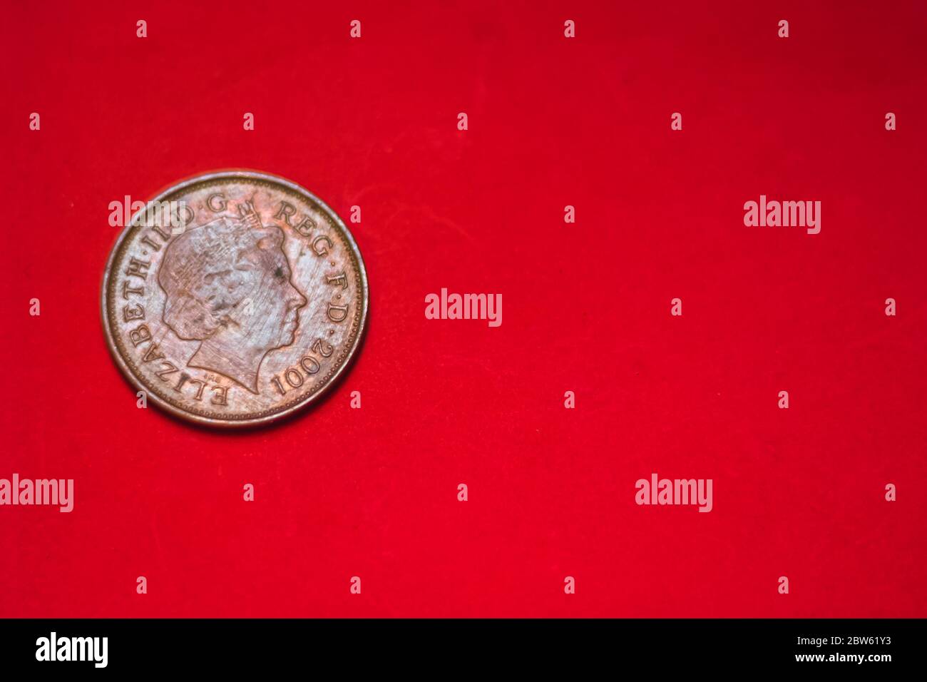 Pièce britannique 2 pence (2001) isolée sur fond rouge avec flou et espace pour la copie de texte. Verso de deux pièces de clôture. Pièces de monnaie collectionneurs de wolrdWide. Banque D'Images