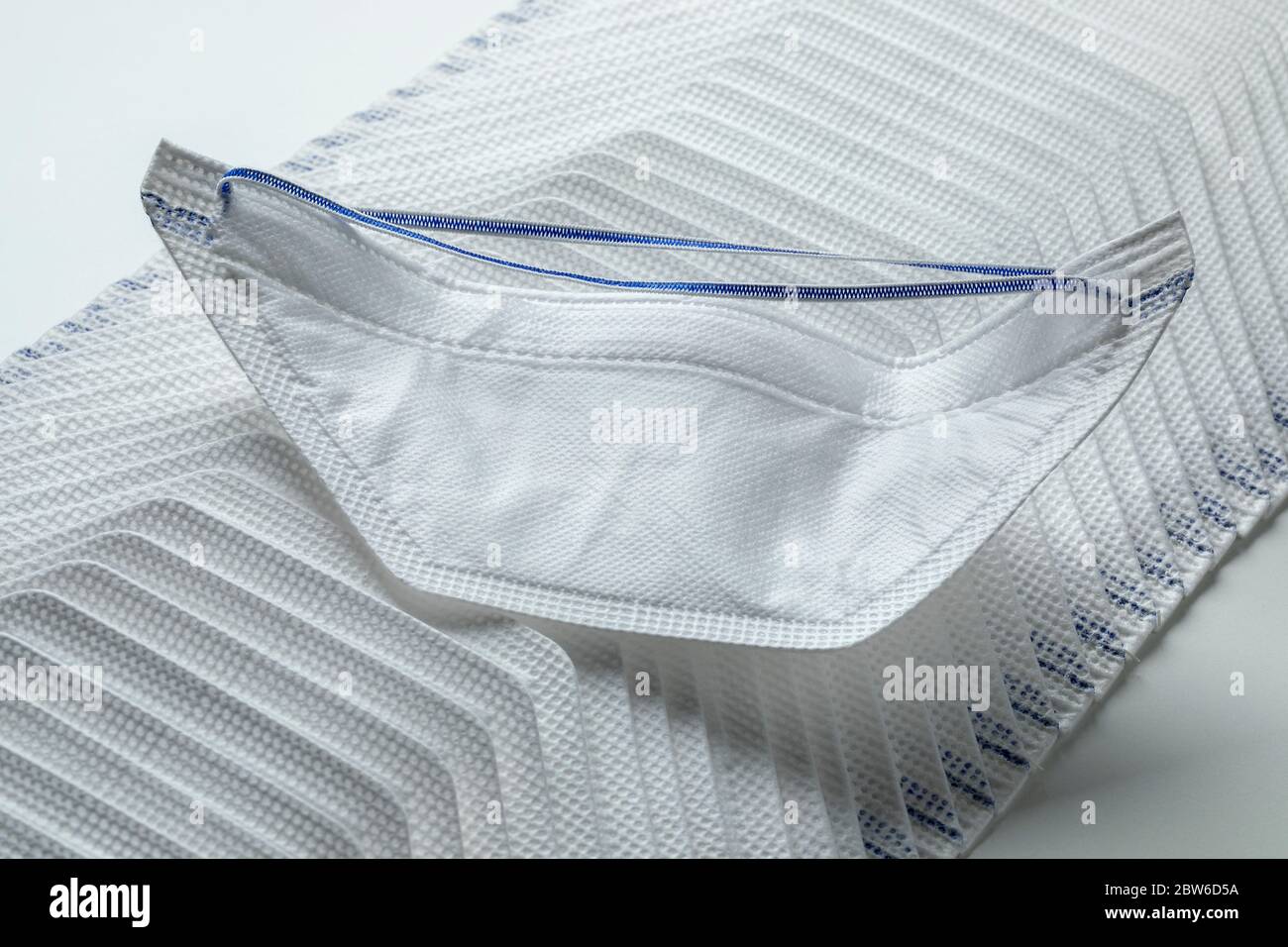 Rangée de masques médicaux de protection sur fond blanc Banque D'Images