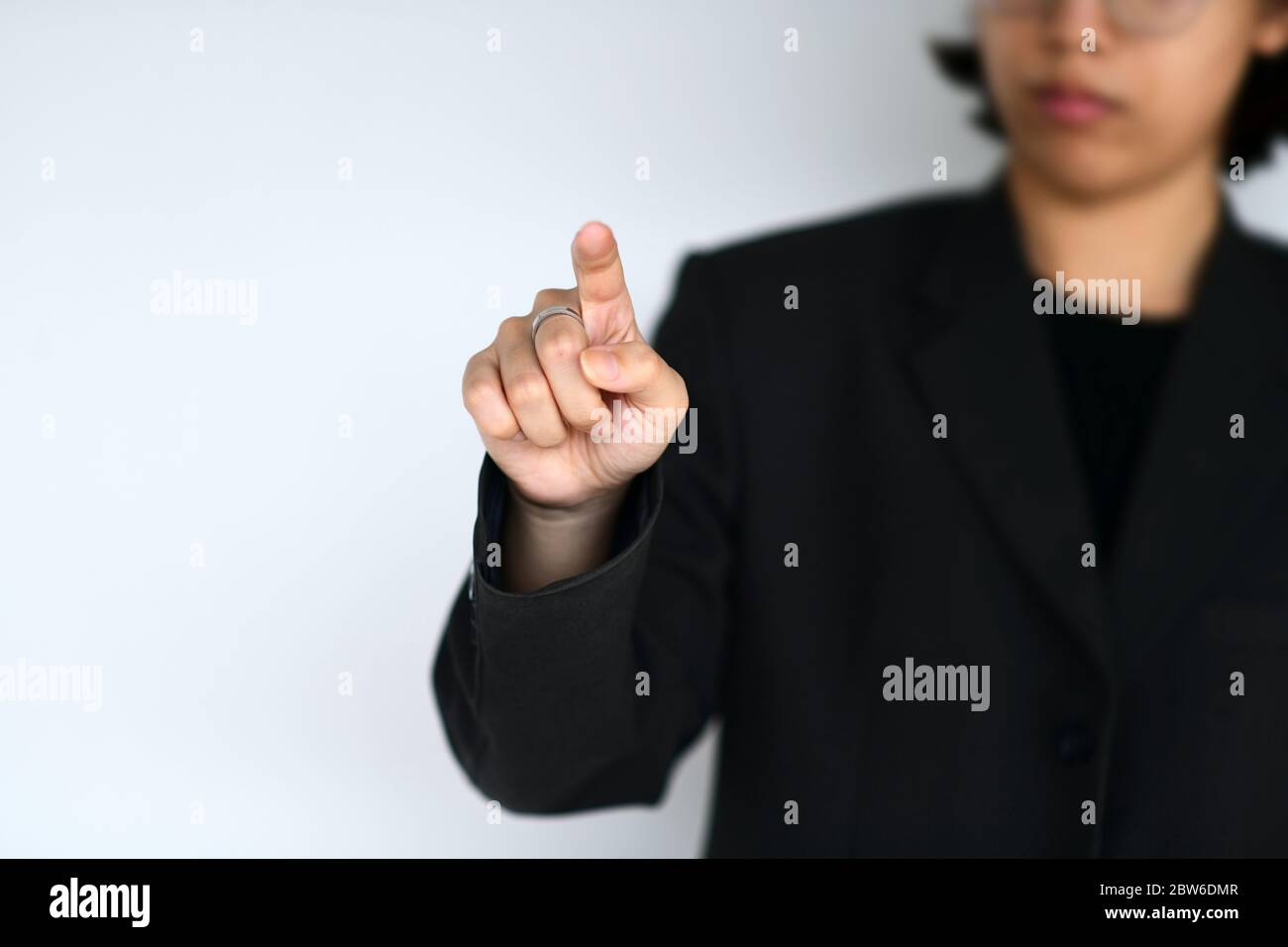 Personne d'affaires en costume point de travail l'air agit comme un écran virtuel numérique, se concentrer sur la main et flou d'arrière-plan Banque D'Images