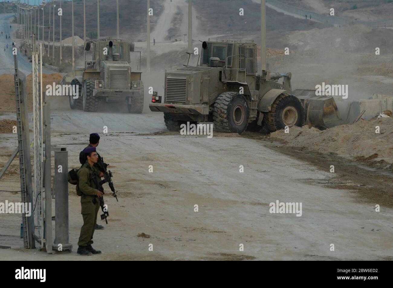 Des bulldozers militaires israéliens bloquent la route peu après que le convoi blindé quitte la bande de Gaza par le passage de Kissufim qui a conduit au bloc 'Gush Katif' des colonies israéliennes dans la bande de Gaza alors qu'Israël met fin à son occupation du territoire palestinien de 38 ans. Banque D'Images