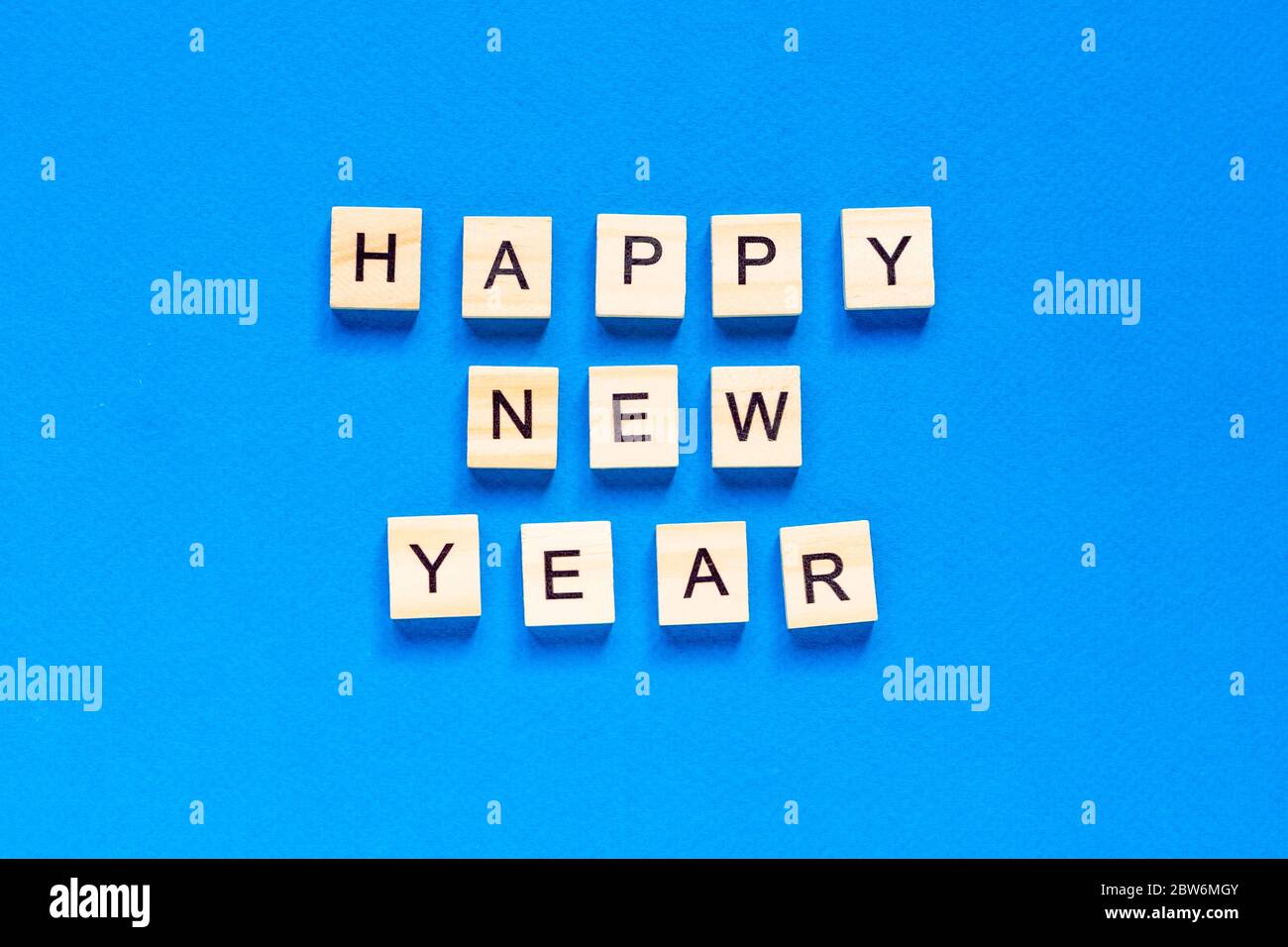 Bonne année écrite en lettres de bois sur fond bleu. Bonne année 2021. Vue du dessus. mise en page. Espace pour le texte. Banque D'Images