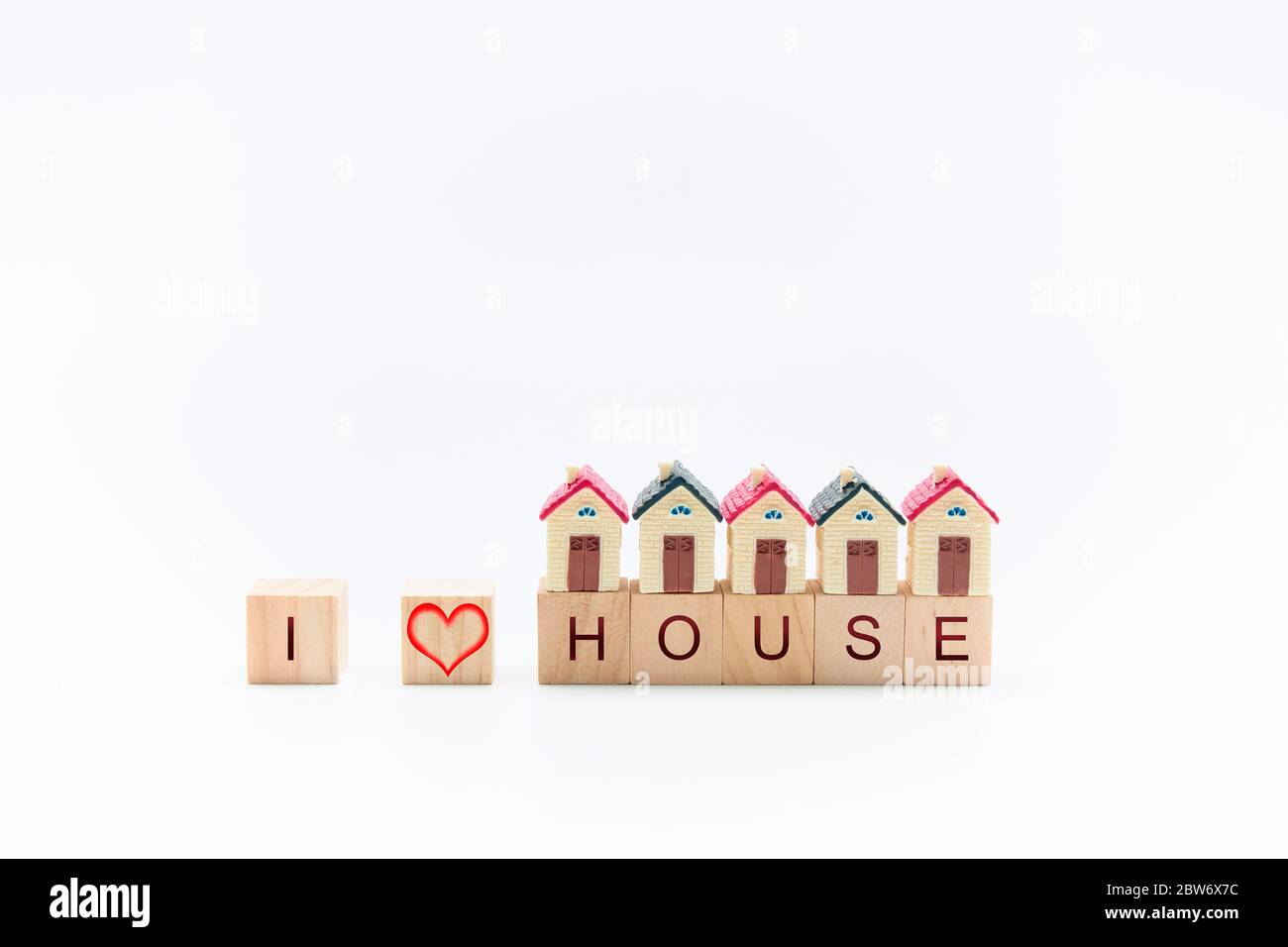 Maisons miniatures en bois avec les mots 'I love House' sur fond blanc. Concept tranquillité et maison Banque D'Images