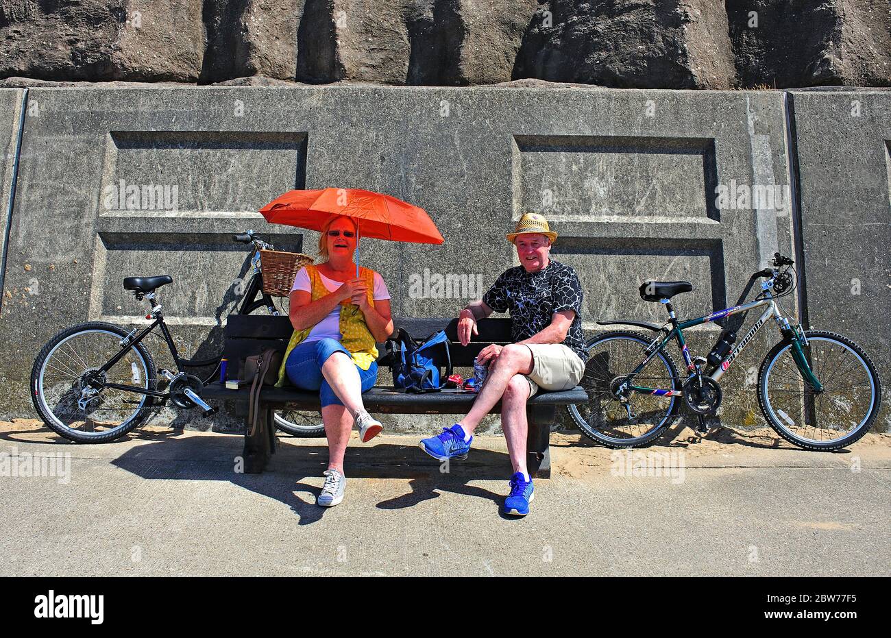 Un couple de cyclistes de moyenne âge s'arrête pour déjeuner lors d'une journée chaude sur le front de mer de Blackpool Banque D'Images