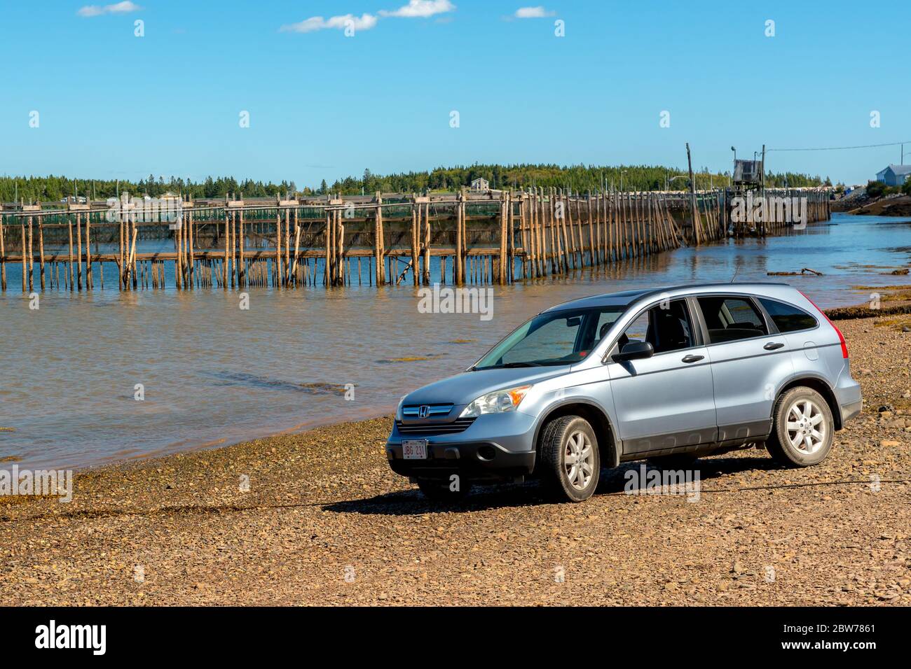 Chance Harbour, Nouveau-Brunswick, Canada - le 8 septembre 2018 : un vus Honda stationné sur une plage au bord de l'océan. Ferme de poissons en arrière-plan. Banque D'Images