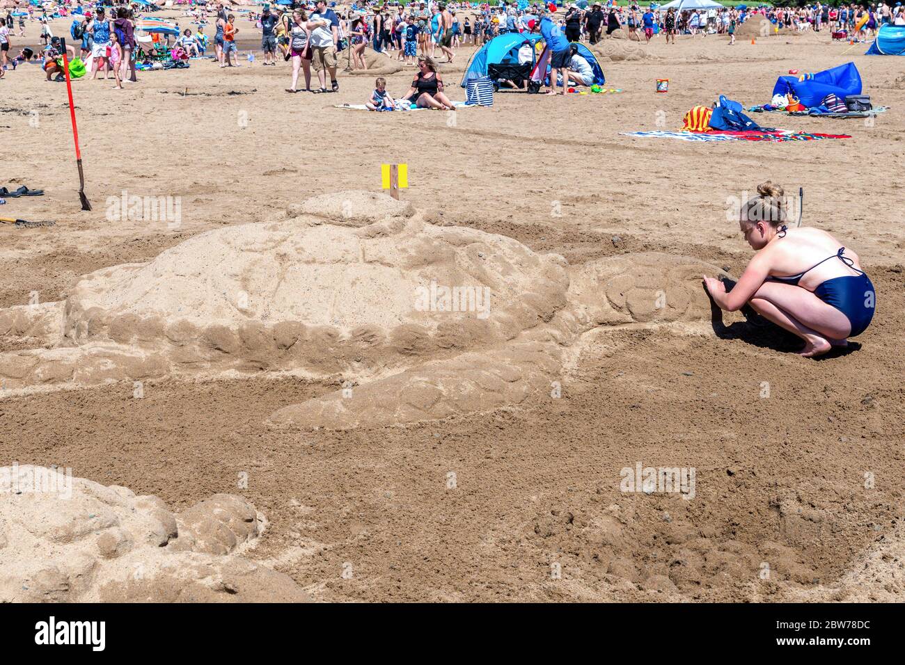 New River Beach, Nouveau-Brunswick, Canada - le 7 juillet 2018 : le concours annuel de sculpture sur sable. Une femme sculpte une tortue. Banque D'Images