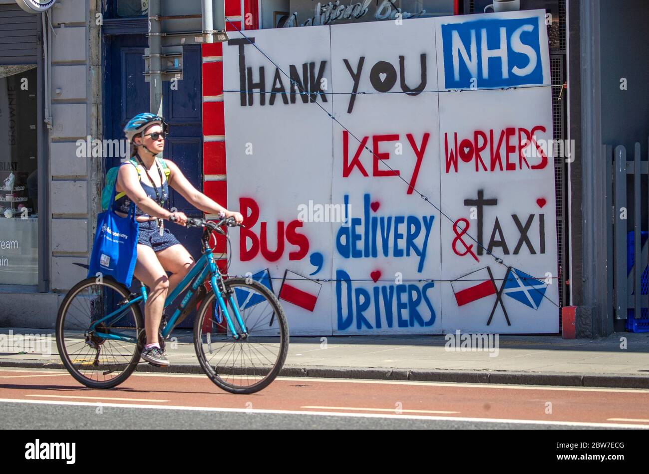 Une femme passe devant une affiche remerciant le NHS et les employés clés d'Édimbourg, car les gens peuvent rencontrer leur famille et leurs amis à l'extérieur et jouer à nouveau à des sports tels que le golf et le tennis, alors que l'Écosse entre dans la première phase du plan du gouvernement écossais pour lever progressivement le confinement. Banque D'Images