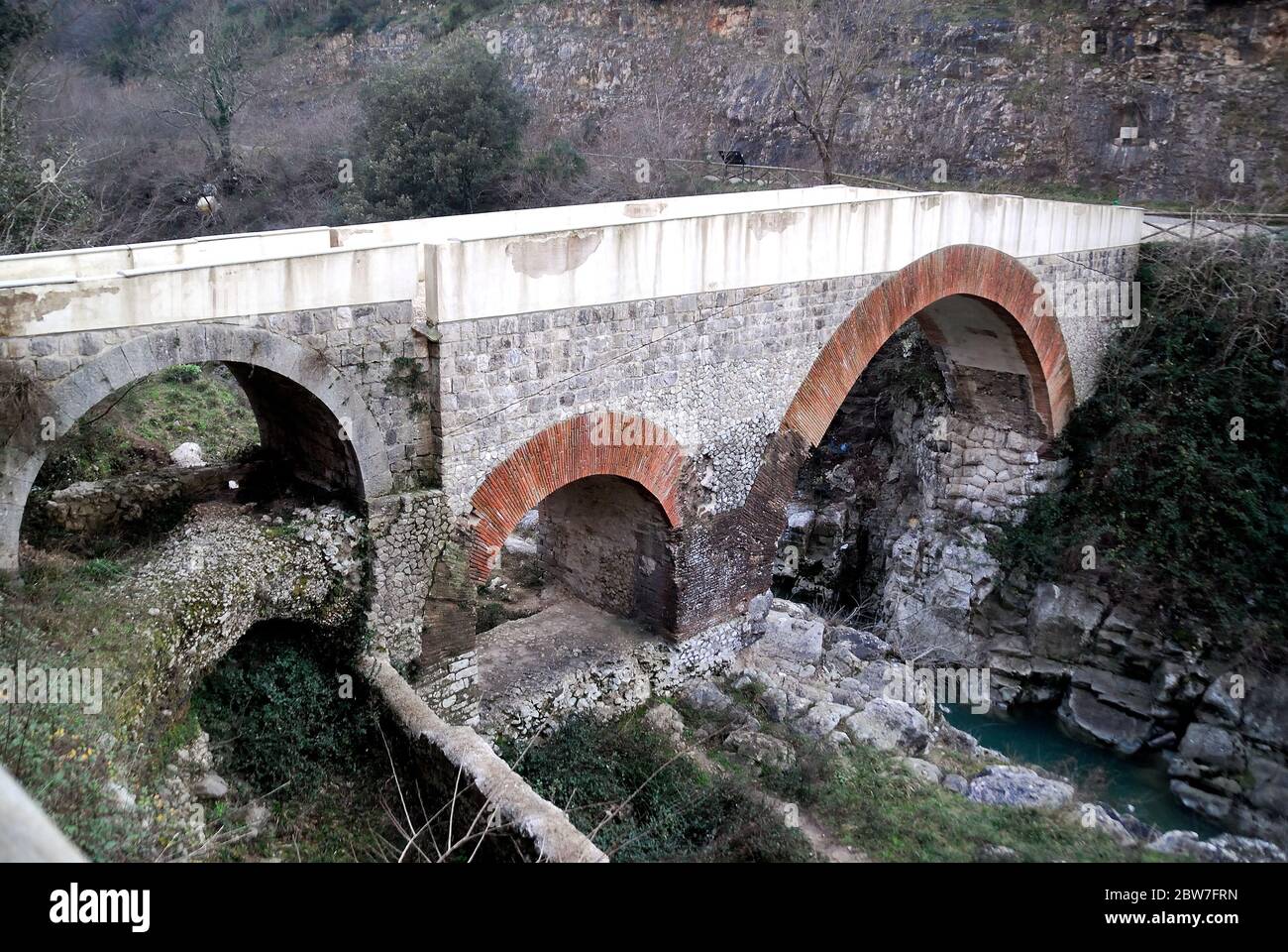 Le pont Fabio Massimo est un ancien pont romain situé dans la municipalité de Faicchio, province de Benevento, Campanie, Italie. Il a été construit dans la période républicaine sur un artefact Samnite préexistant. La tradition veut que le dictateur romain Quinto Fabio Massimo passe là pour arrêter l'avance d'Hannibal pendant la deuxième guerre punique. En 2008, le pont a subi une intervention de restauration douteuse en raison de l'utilisation de techniques sans rapport avec l'artefact. Le pont est situé près d'une gorge sur la rivière Titerno. Banque D'Images