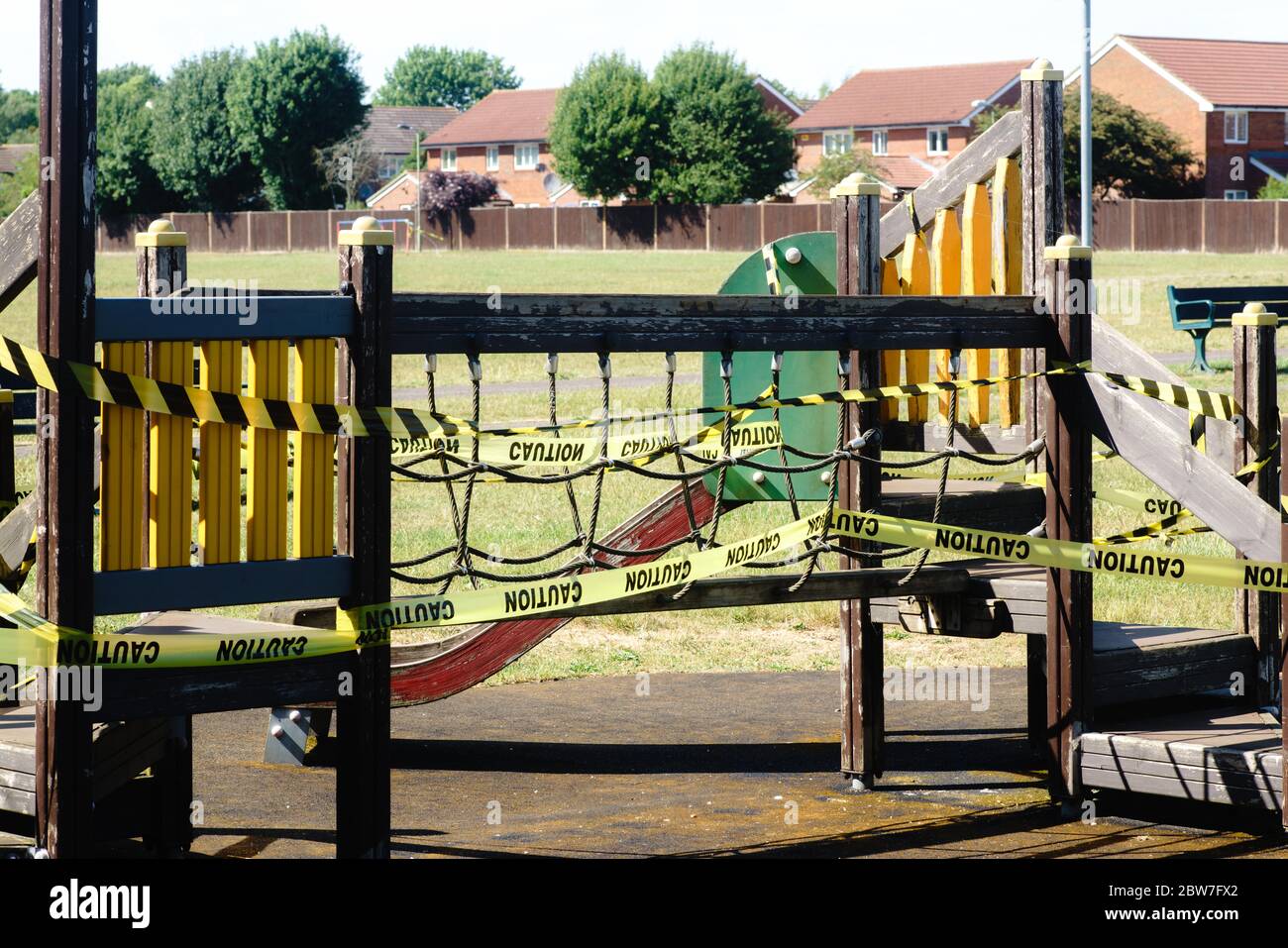 Un ruban d'avertissement « ATTENTION » entoure un cadre d'escalade dans une aire de jeux pour enfants. Pandémie de coronavirus Banque D'Images