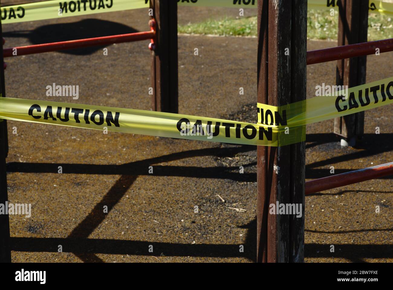 Un ruban d'avertissement « ATTENTION » entoure un cadre d'escalade dans une aire de jeux pour enfants. Pandémie de coronavirus Banque D'Images