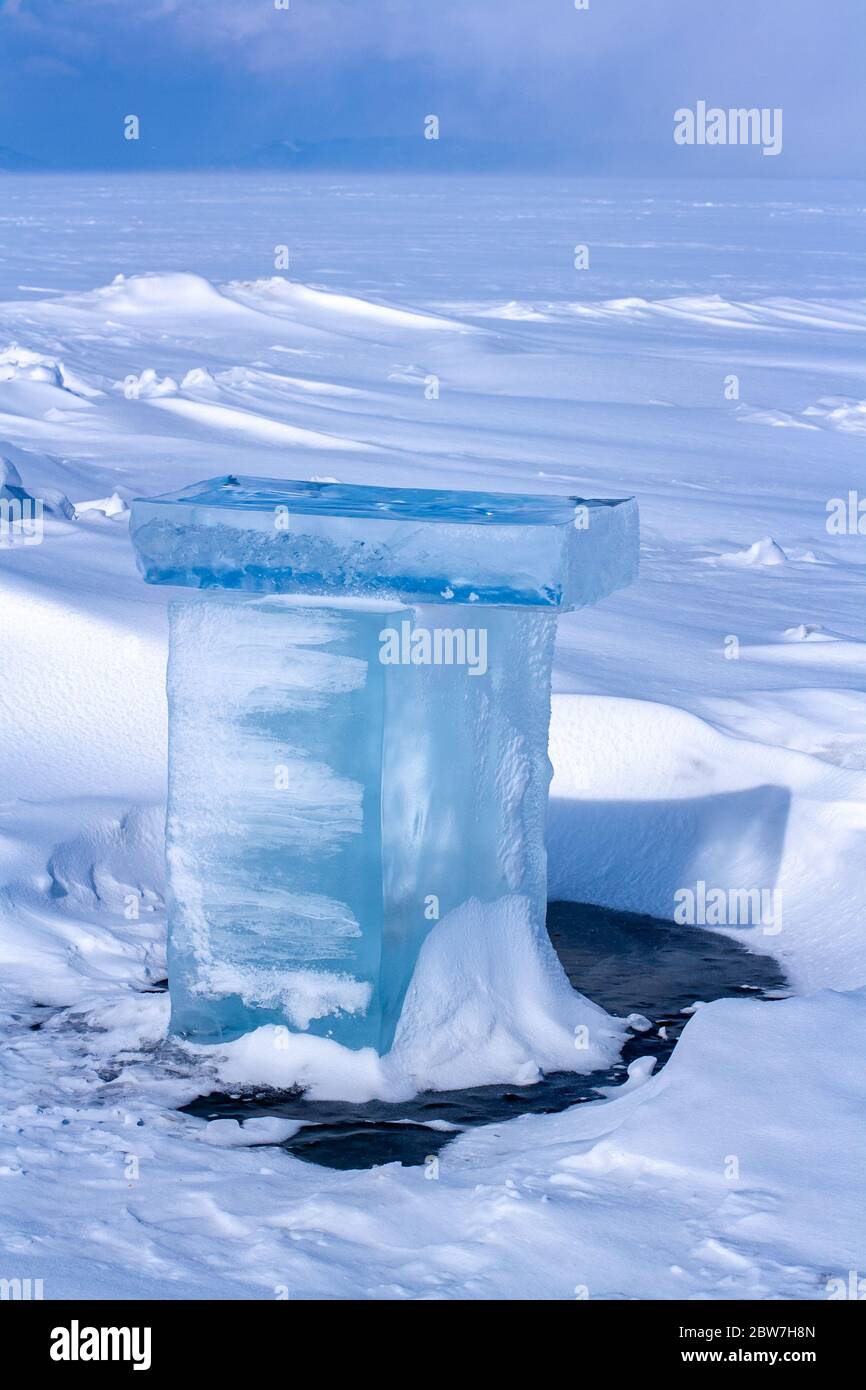 Fondu dans les morceaux de glace du soleil dans les hummocks enneigés du lac Baikal. La glace est recouverte de neige. Paysage d'hiver. Concentrez-vous sur la glace. Banque D'Images