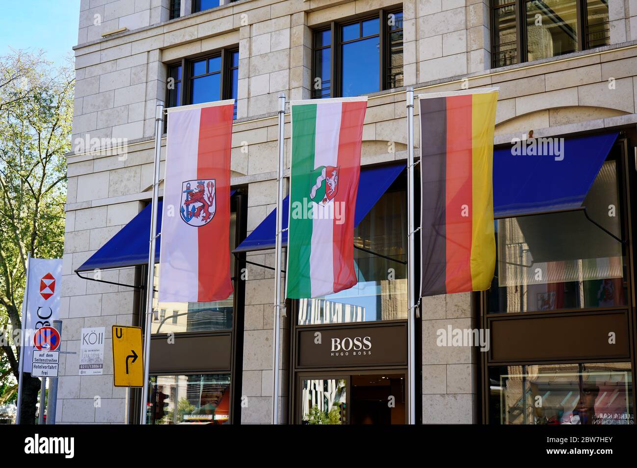 Les drapeaux de Düsseldorf, de Rhénanie-du-Nord-Westphalie et d'Allemagne (de gauche à droite) devant un bâtiment commercial de Königsallee. Banque D'Images
