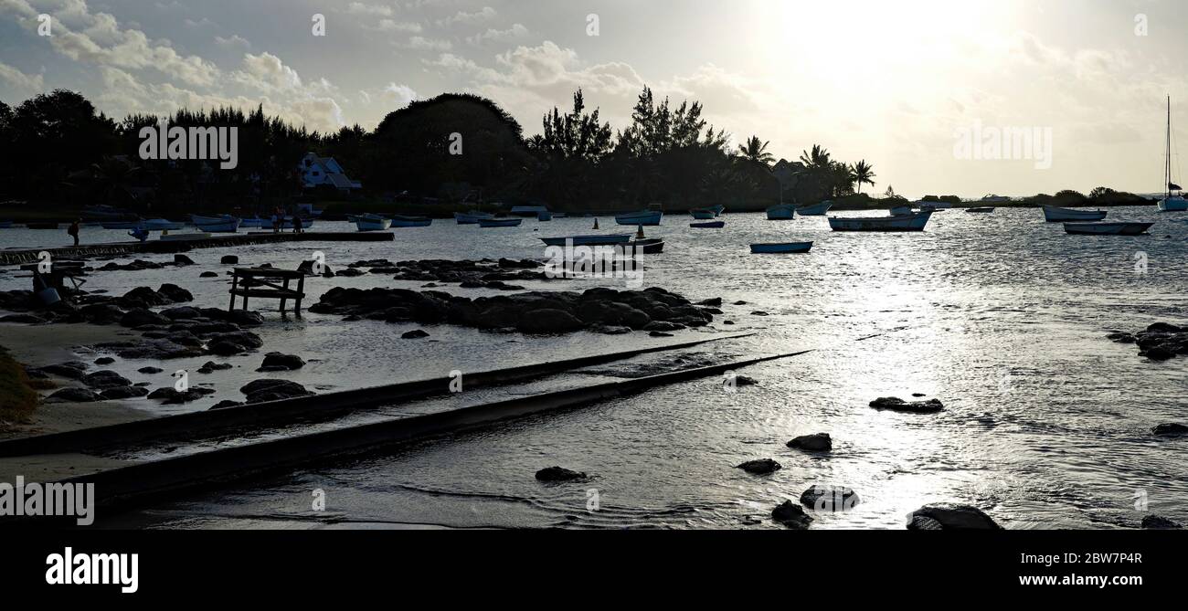 Coucher de soleil sur le bord du Cap Malheureux avec de petits bateaux en arrière-plan, Maurice. Banque D'Images