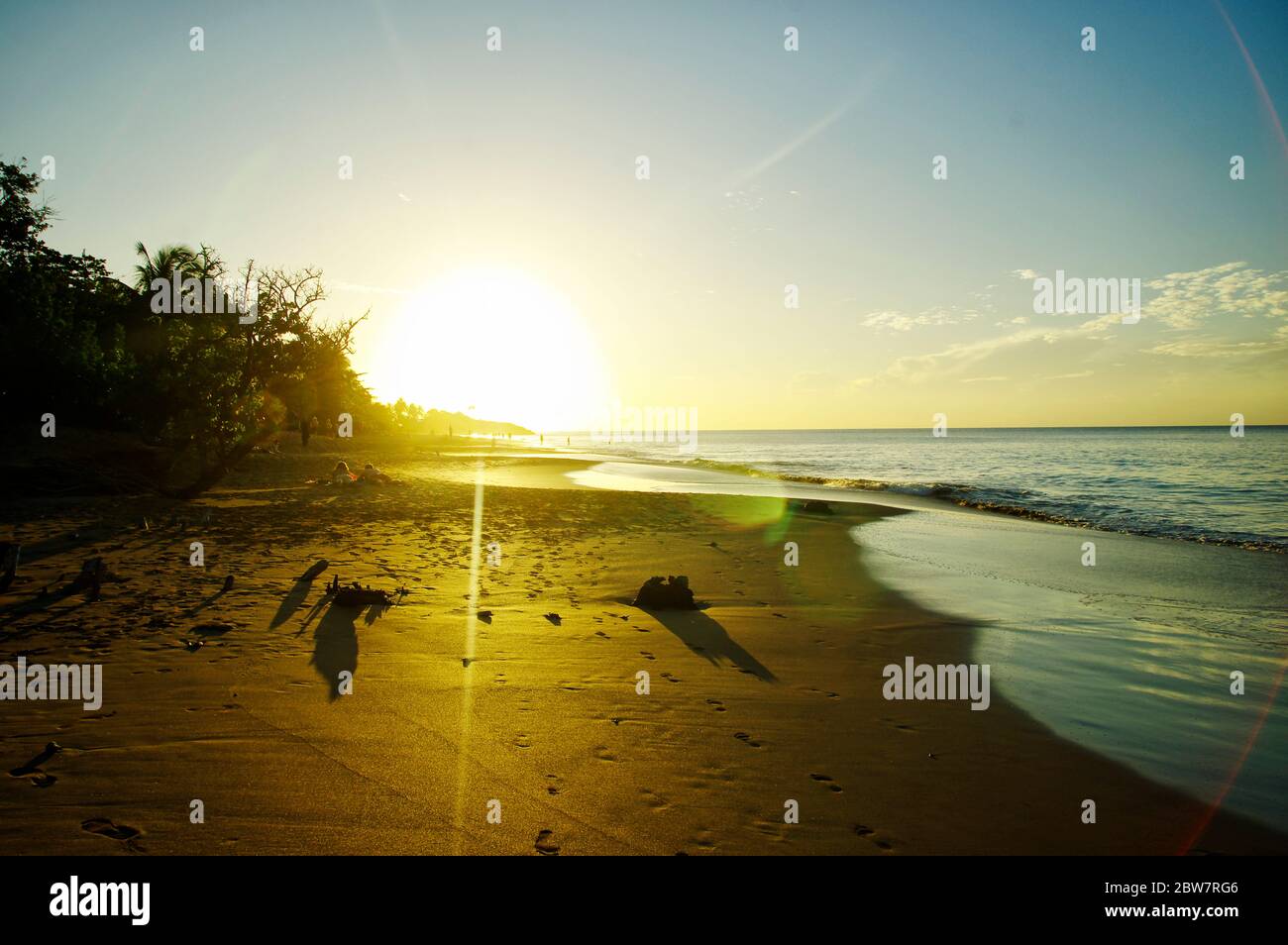 BASSE-TERRE/GUADELOUPE - 12 JANVIER 2019 : personnes prenant un bain de soleil au coucher du soleil sur la belle plage de la Perle sur Basse-Terre sur l'île de la Guadeloupe Banque D'Images