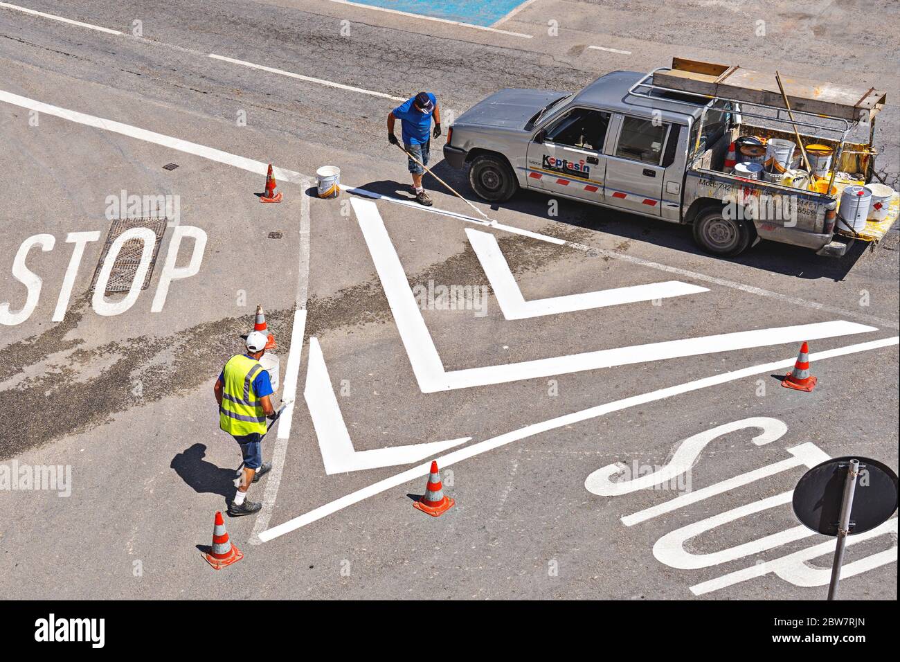 Peinture de la ligne de trafic. Les travailleurs peinent à peindre des lignes de rue blanches à la croisée des chemins. Rafraîchissement des marquages routiers: Xghajra, Malte - 29 mai 2020 Banque D'Images