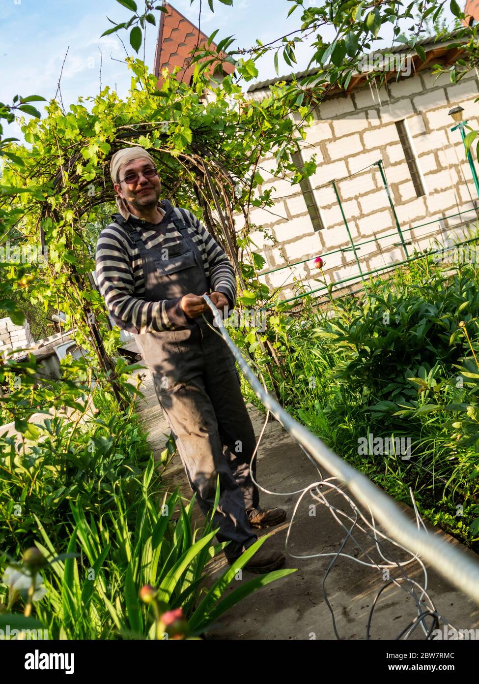 Un mâle caucasien adulte tire le câble dans une gaine de protection métallique. Banque D'Images