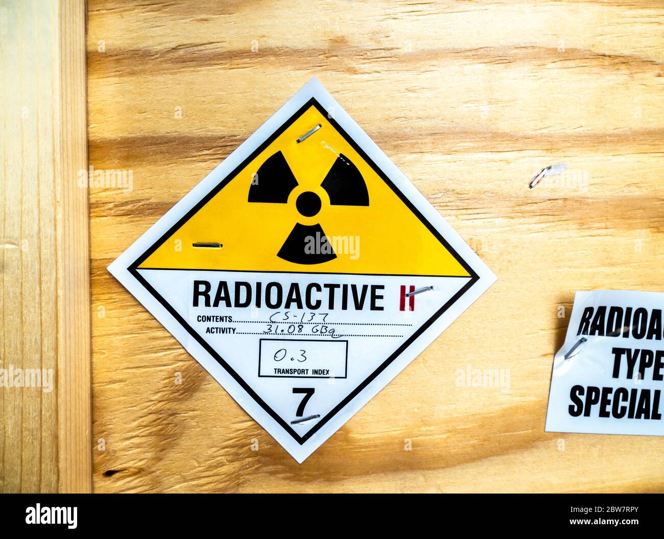 Étiquette d'avertissement relative aux matières radioactives à côté de l'emballage en bois standard de transport Banque D'Images