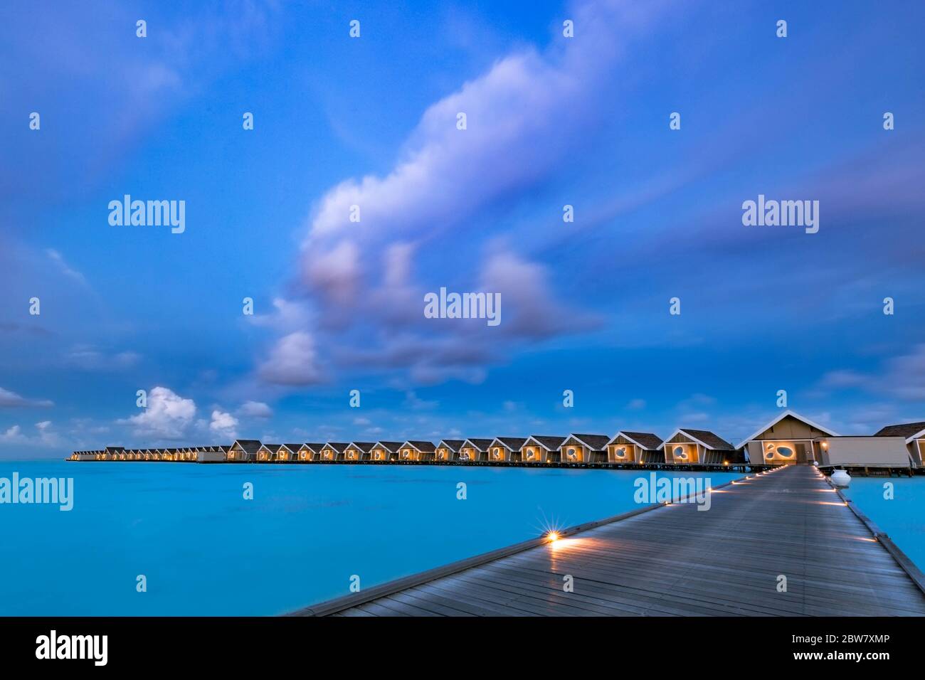 Coucher de soleil sur l'île des Maldives. Station balnéaire de bungalows d'eau à la plage des îles. Océan Indien, Maldives. Magnifique coucher de soleil, station de luxe et ciel coloré Banque D'Images