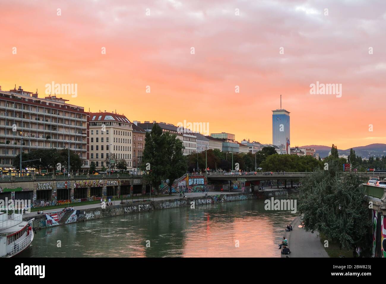 VIENNE, AUTRICHE - 23 AOÛT 2016 : vue sur le canal du Danube à Vienne au coucher du soleil en été. On peut voir les gens assis dehors. Banque D'Images