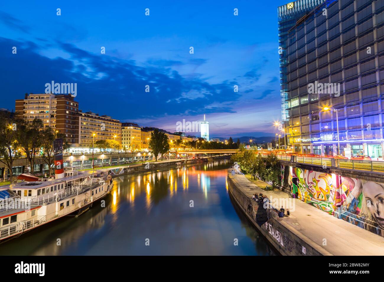 VIENNE, AUTRICHE - 21 AOÛT 2015 : une vue sur le canal du Danube peu après le coucher du soleil. Les gens, les bâtiments et les bars peuvent être vus. Banque D'Images