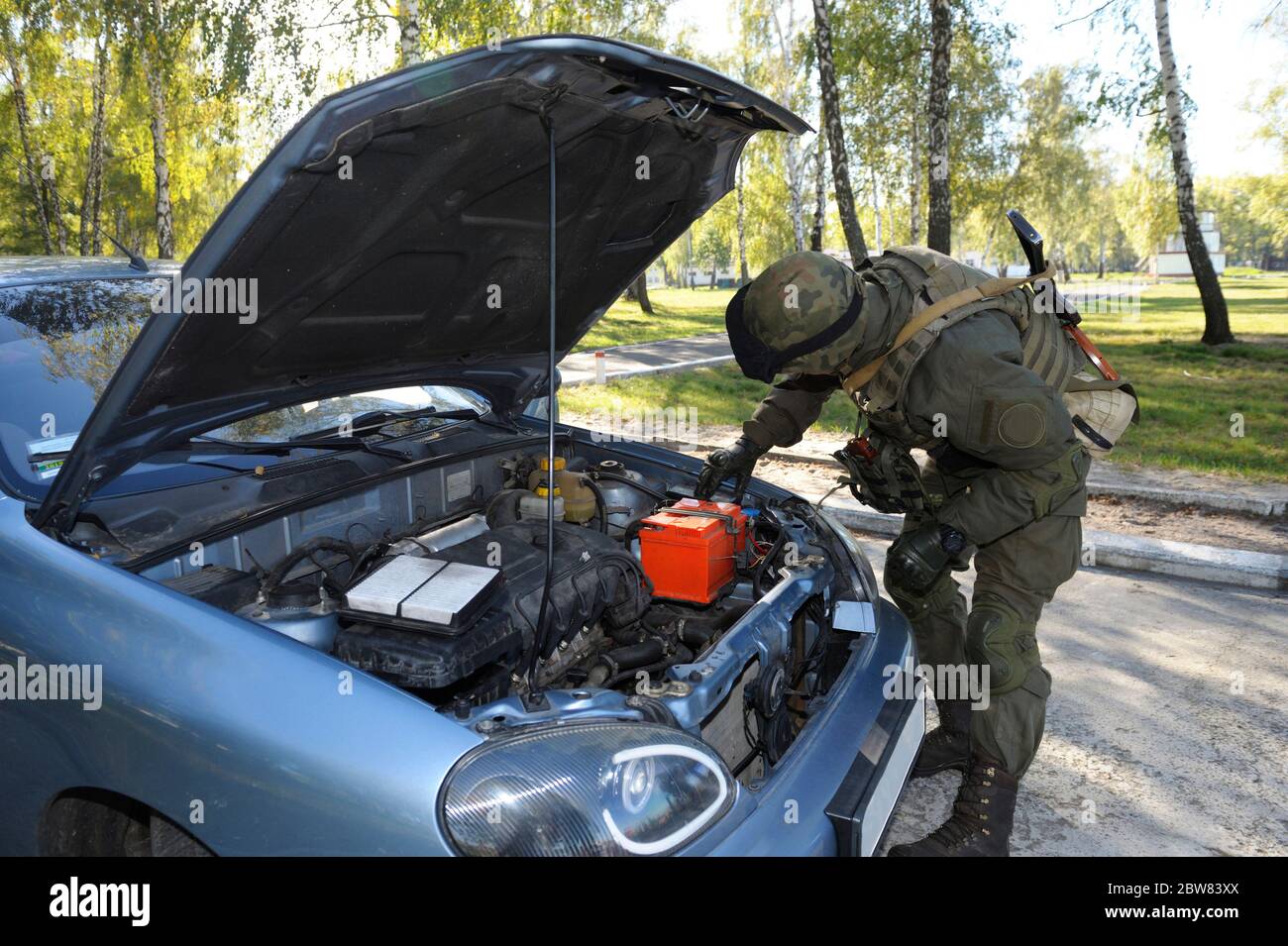 Au point de contrôle, la formation. Soldat recherchant les effets personnels du suspect dans une voiture arrêtée Banque D'Images