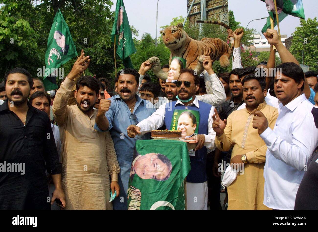 Les dirigeants et les activistes de la Ligue musulmane (PML-N) ont coupé le gâteau lors de la cérémonie de célébration à propos de Youm-e-Takbeer (le jour où le Pakistan a effectué des essais nucléaires le 28 mai 1998, en réponse aux explosions nucléaires indiennes), devant le club de presse de Lahore le samedi 30 mai 2020. Banque D'Images