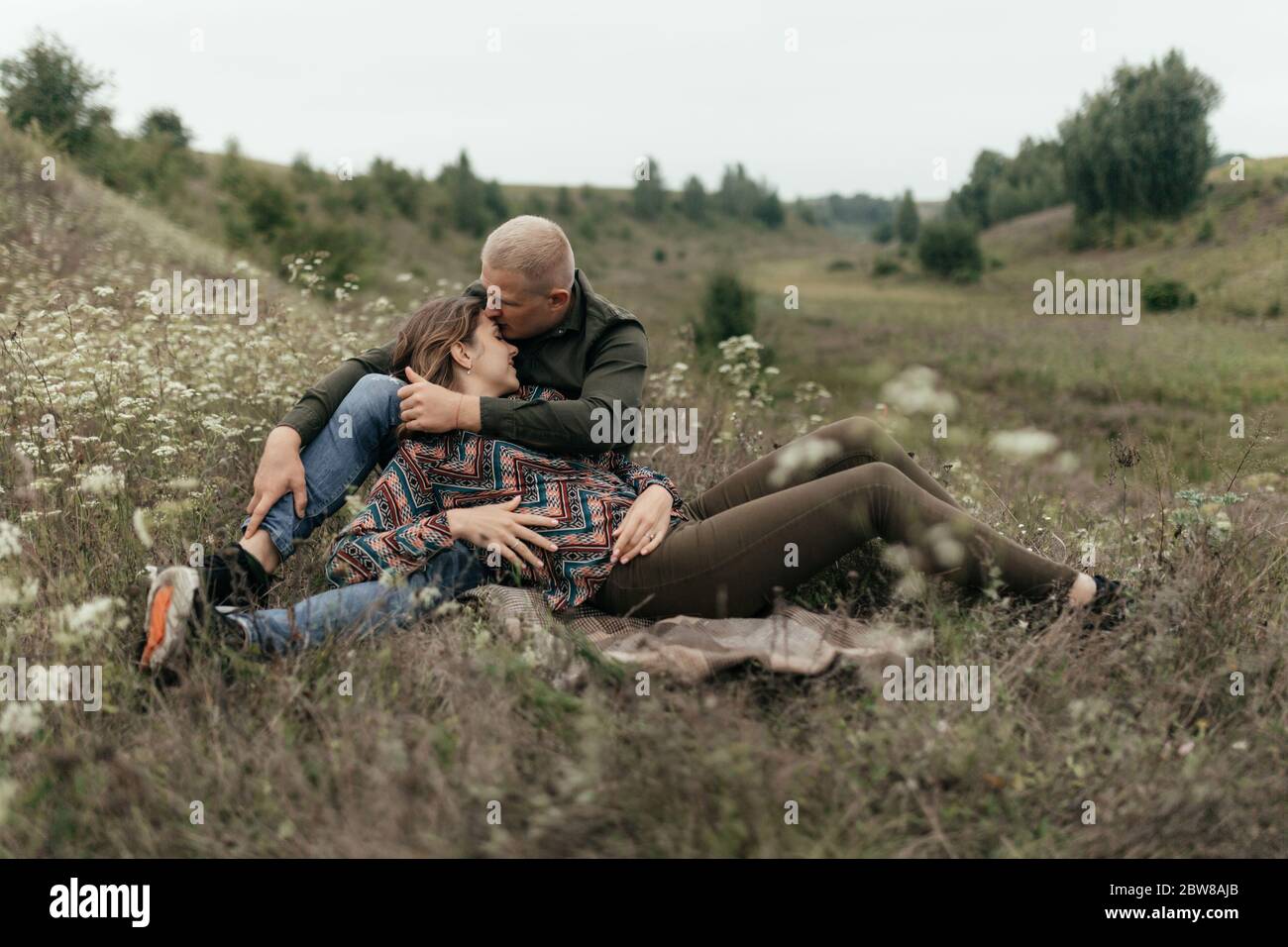 Jeune couple amoureux allongé sur la couverture dans la nature. Couple heureux Banque D'Images