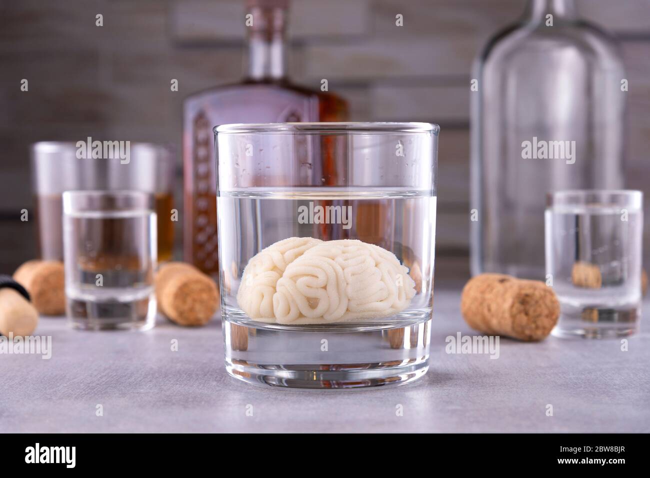 cerveau humain dans un verre avec une boisson alcoolisée, sur fond de bouteilles avec de l'alcool. Dépendance à l'alcool. Dommage au cerveau de l'alcool Banque D'Images