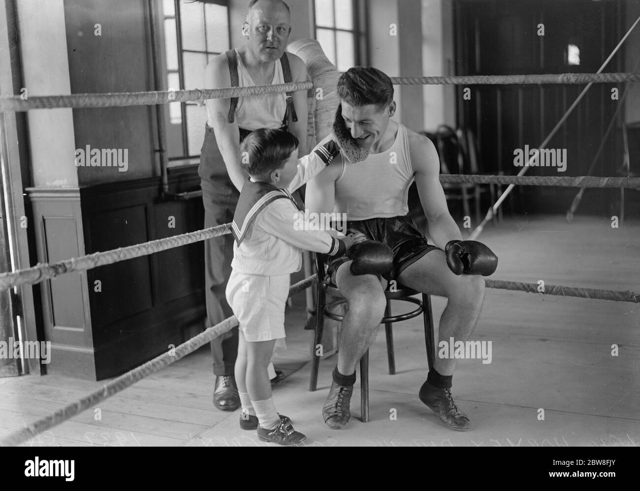Le fils de Len Harvey visite le camp d'entraînement de son père pendant son entraînement pour le match du titre du monde . Terry pond le visage de son père après un entraînement à Whetstone . 18 juin 1932 Banque D'Images
