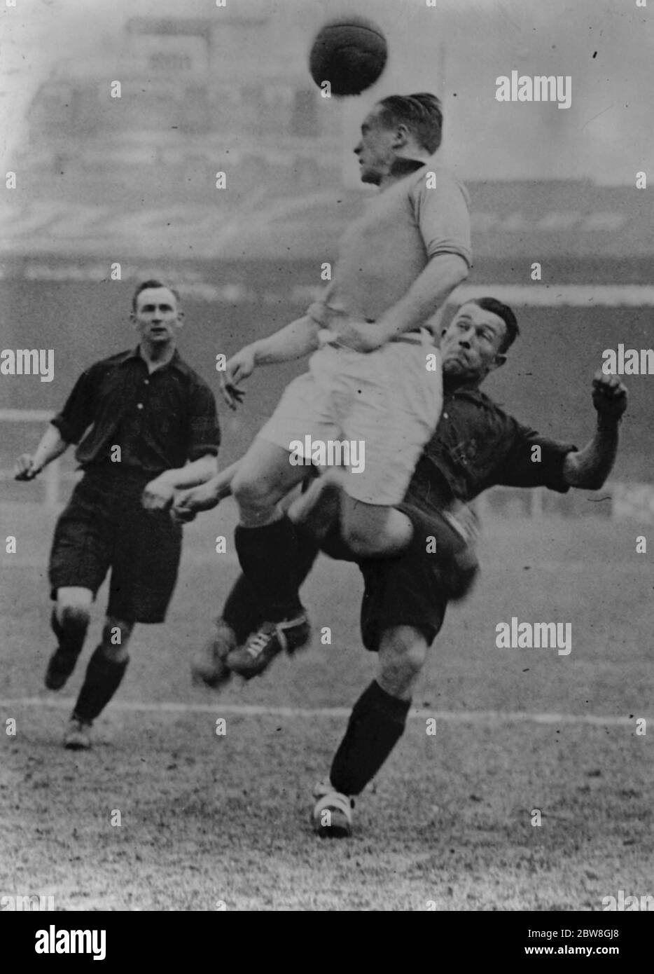 Match de football français contre armée britannique . Un joueur français saute pour le ballon poursuivi par deux Anglais avant pendant le match de football de l'Armée française contre l'Armée britannique au stade Buffalo . 4 mars 1932 Banque D'Images