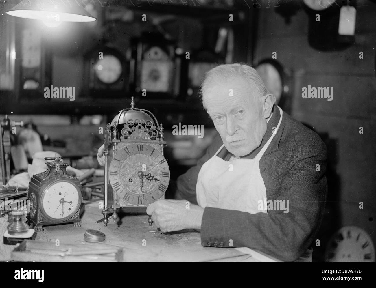Plus de soixante ans au même banc . M. Philip Ebmer , un horloger d'Oxford Street , qui célèbre son 78e anniversaire cette semaine , travaille au même banc depuis 60 ans . 9 novembre 1933 Banque D'Images