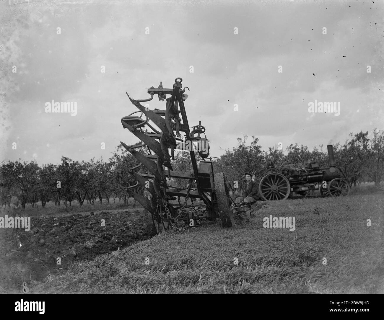 Un agriculteur utilise un moteur à vapeur pour labourer un champ . 1935 . Banque D'Images