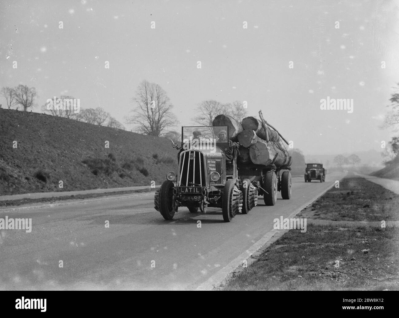 Charge lourde de grumes remorquées par un tracteur . 1935 . Banque D'Images