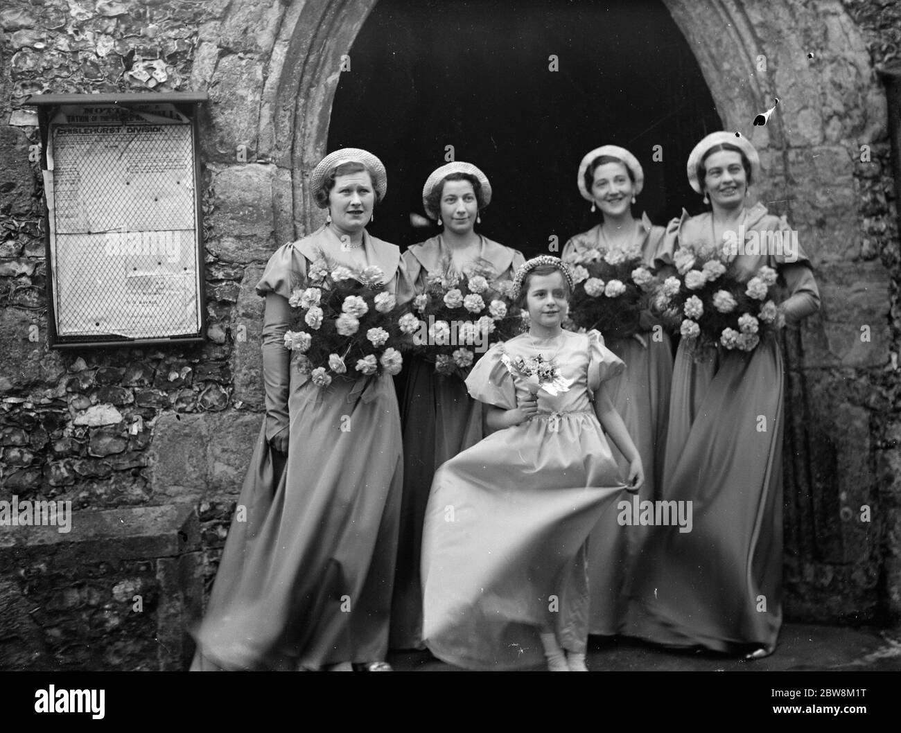Un groupe de bridesmaids à l'extérieur de l'église . 1935 Banque D'Images