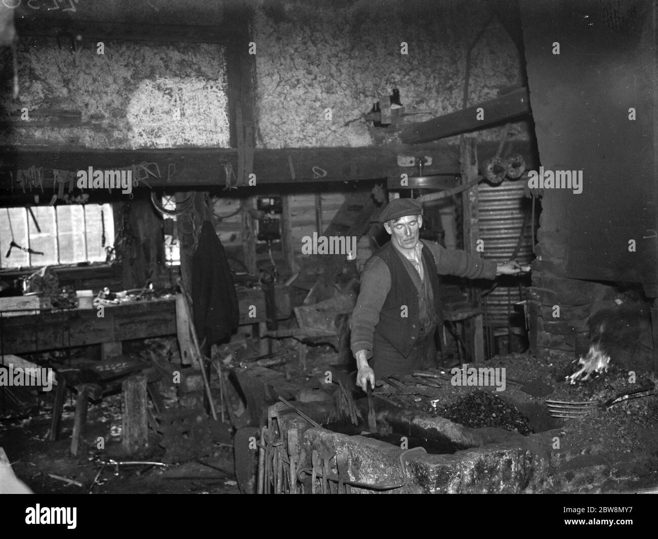 Le forgeron au travail dans la forge Westerham . 1935 Banque D'Images Le forgeron au travail dans la forge Westerham . 1935 Banque D'Images