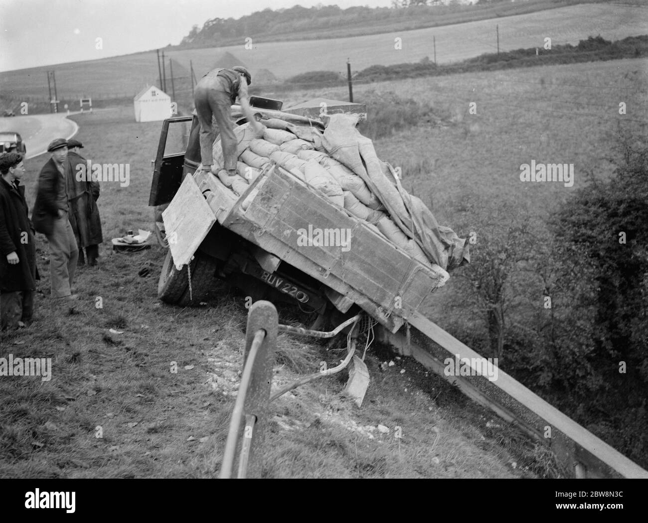 Déchargement de sacs d'un camion endommagé après un accident à Farningham , Kent . 1935 Banque D'Images