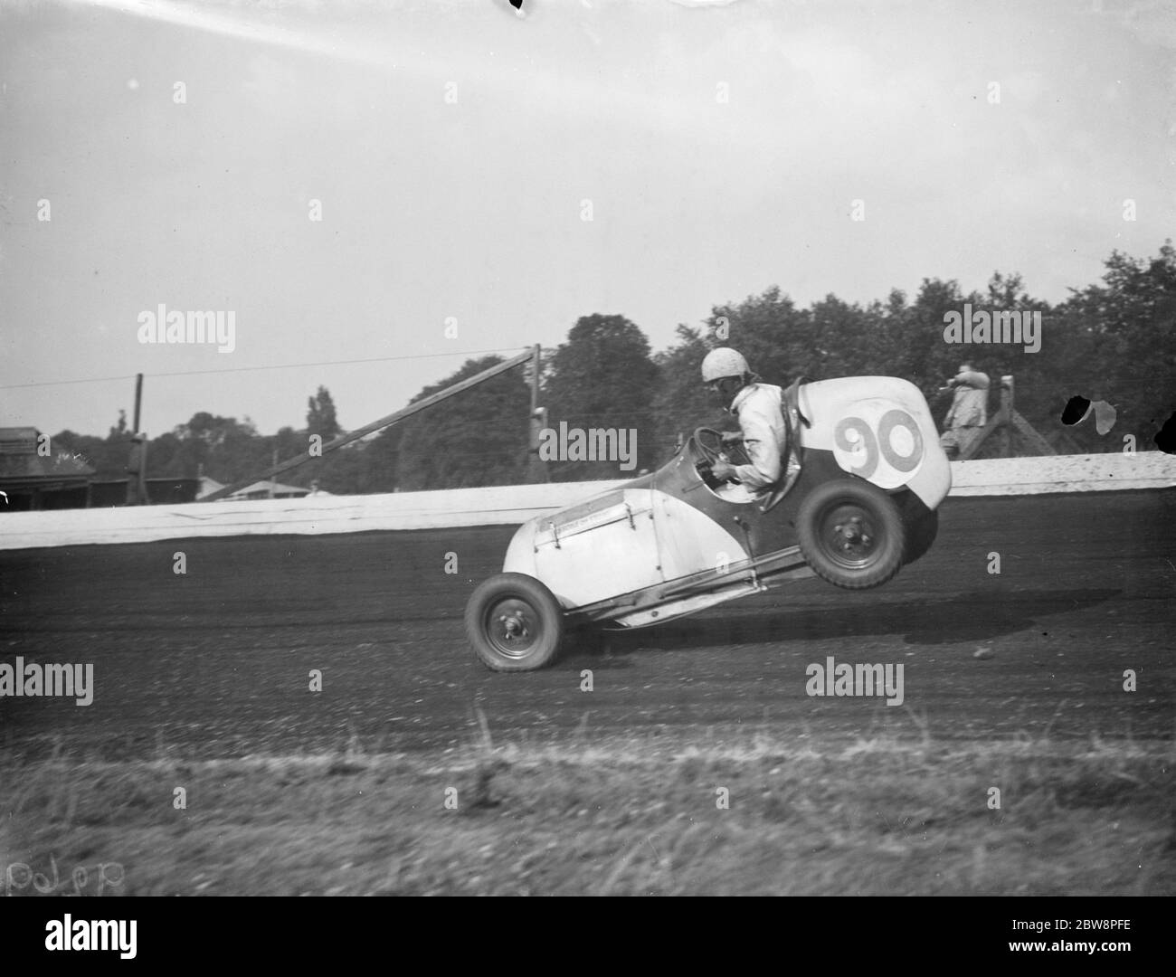 Le Grand prix de la course de voitures miniatures Crystal Palace . Frank Chiswell lève l'arrière de sa voiture de course . 1938 Banque D'Images