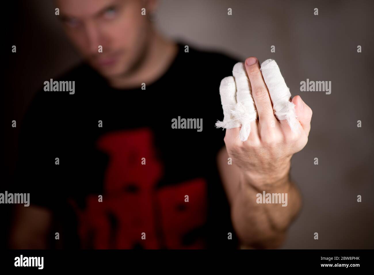 un homme montre une main avec des doigts bandés, le doigt du milieu n'est pas bandé Banque D'Images