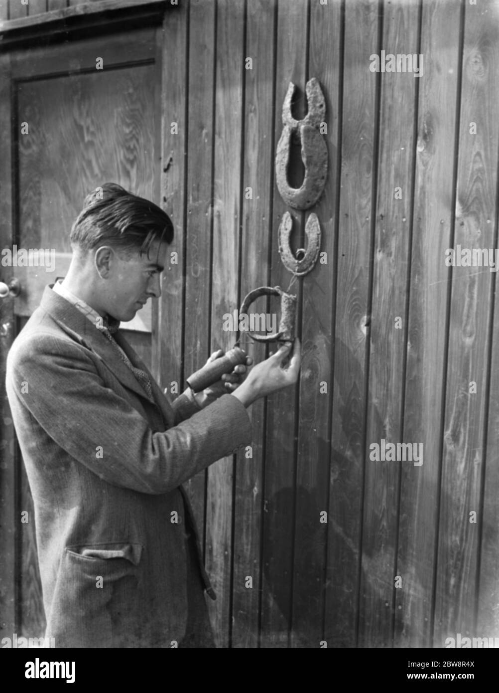 M. Greenfield examine les fers à cheval et les étriers trouvés sur le site d'excavation d'une villa romaine dans la vallée de Cray , dans le Kent . 1936 . Banque D'Images