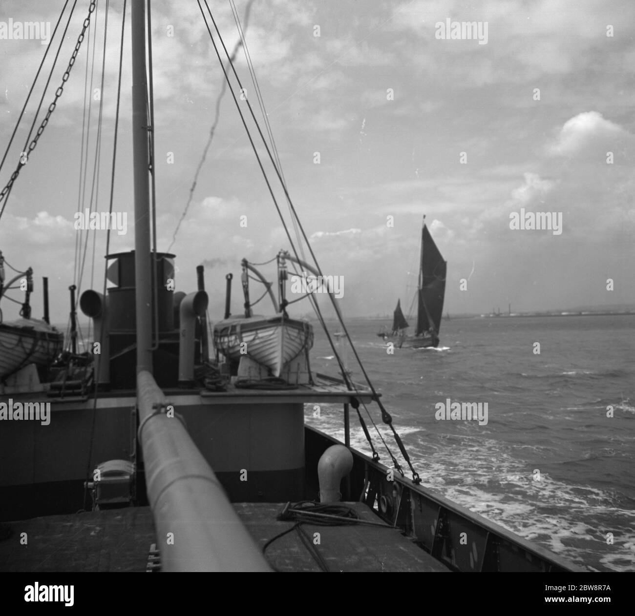 Bateau passant une barge de voile sur la Tamise . 1936 Banque D'Images