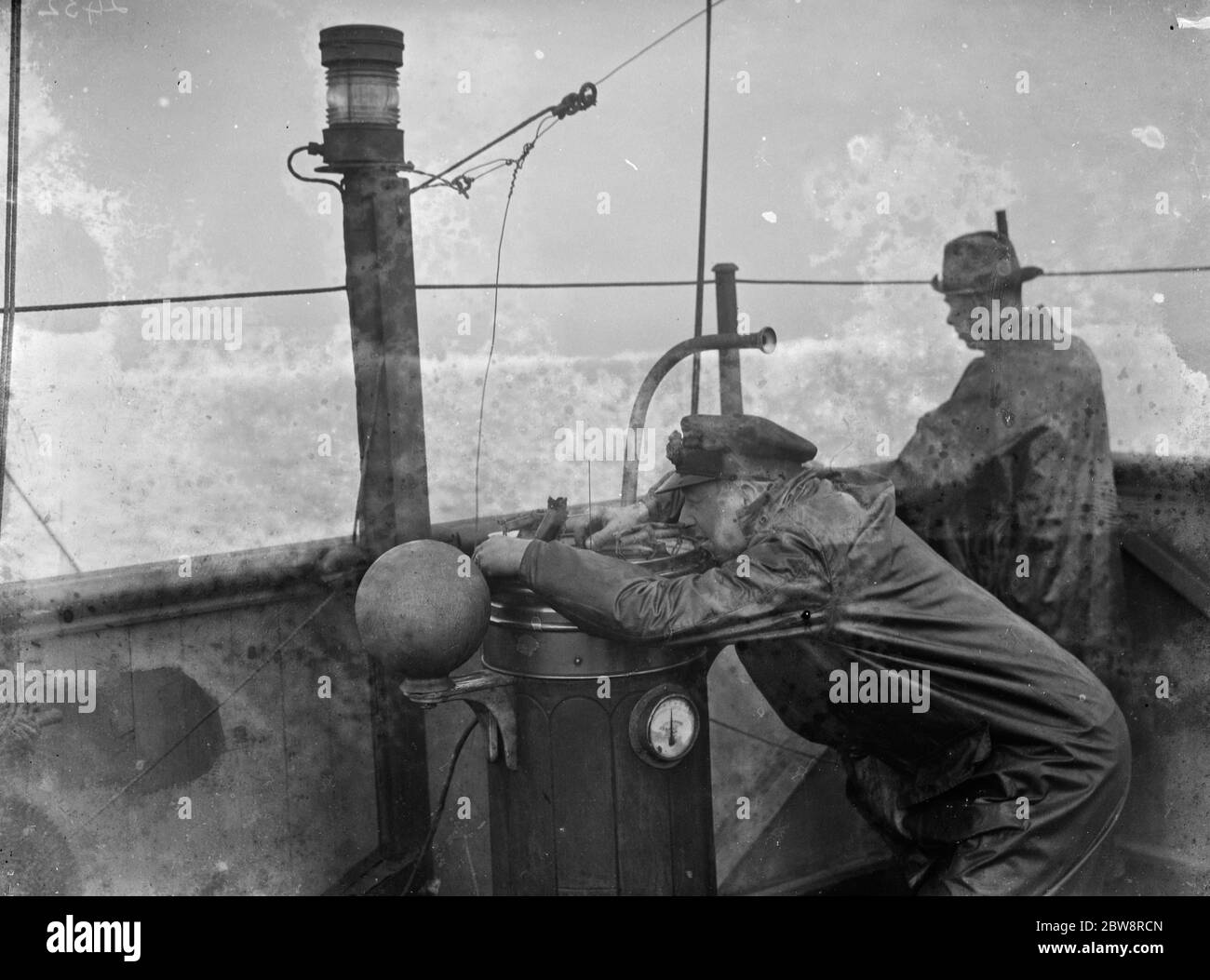 Le capitaine du bateau à vapeur à tramp, le SS Eston, lit le compas sur le pont du navire. 1935 Banque D'Images